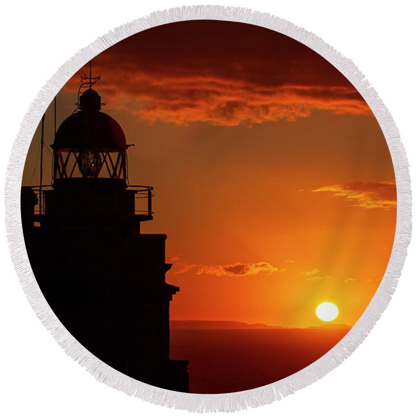 Night Round Beach Towel featuring the photograph Cape Prior Silhouetted Lighthouse against Orange Sky Sunset and Sun at the Horizon Ferrol La Corua Galicia by Pablo Avanzini