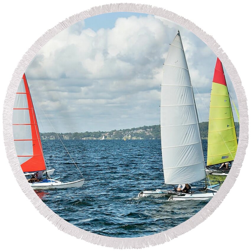 Csne62 Round Beach Towel featuring the photograph Children Sailing small catamiran sailboats with colourul sails. by Geoff Childs