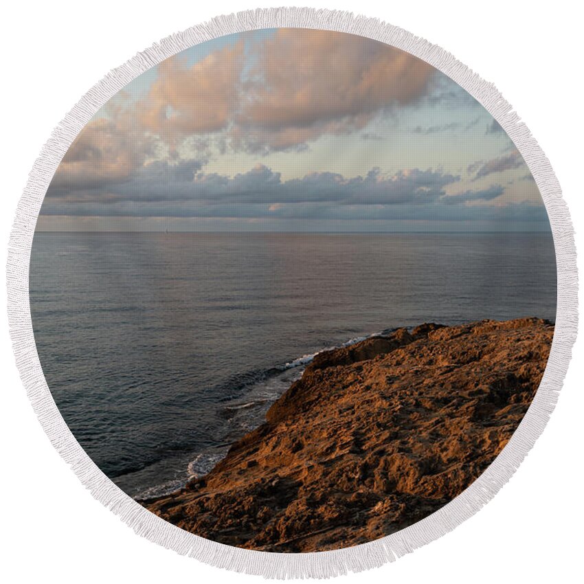Mediterranean Sea Round Beach Towel featuring the photograph Red-brown rocks and pink clouds on the Mediterranean Sea by Adriana Mueller
