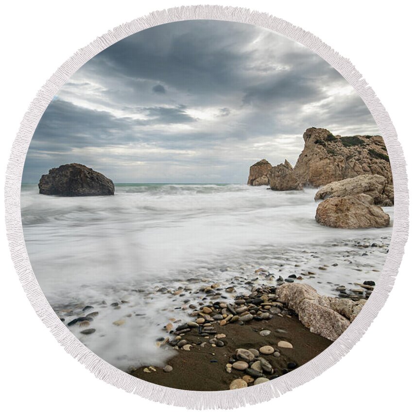 Seascape Round Beach Towel featuring the photograph Seascape with windy waves splashing at the rocky coastal area. by Michalakis Ppalis