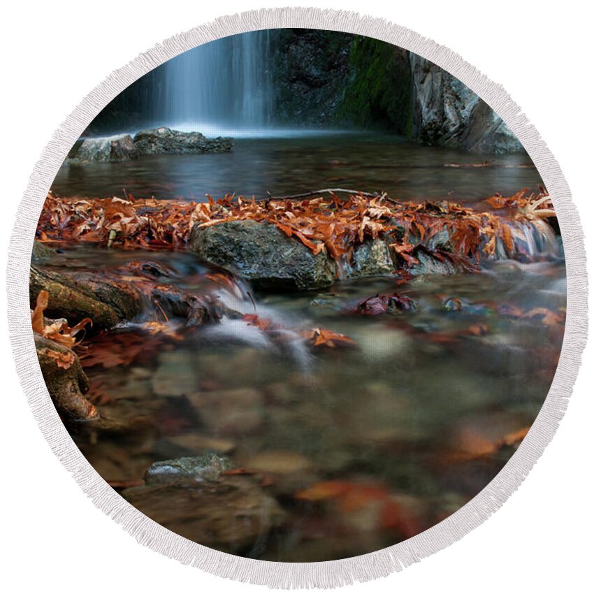 Troodos Round Beach Towel featuring the photograph Waterfall and river flowing with maple leaves on the rocks on the river in Autumn by Michalakis Ppalis