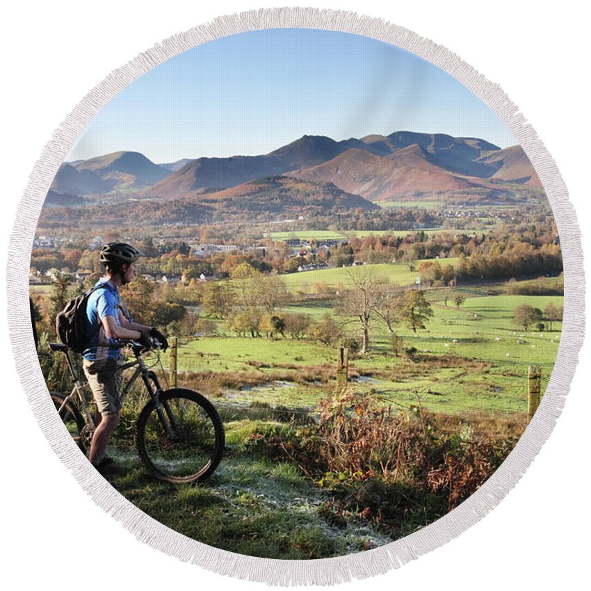 Young Round Beach Towel featuring the photograph Young couple on bikes looking over Cumbrian fells, England, UK by Bryan Attewell
