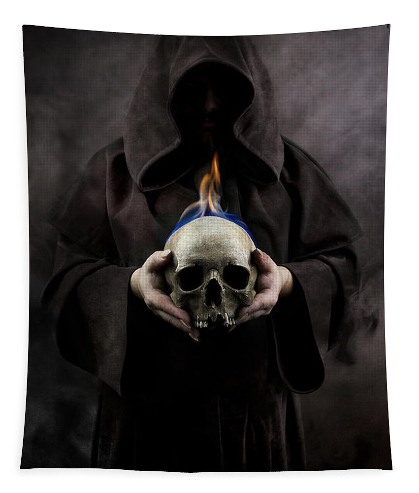 Hood Tapestry featuring the photograph Man in the hooded cloak holding burning human skull in his hand by Jaroslaw Blaminsky