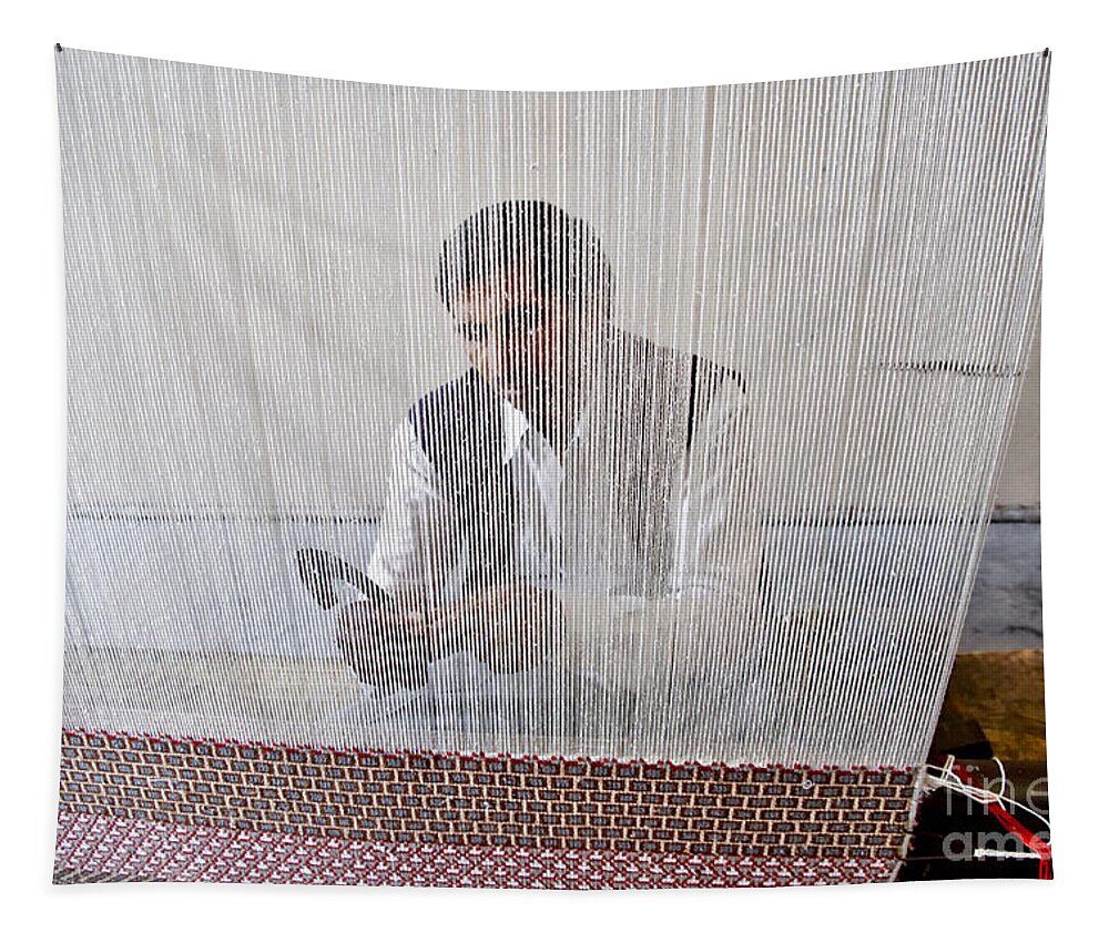 Carpet Weaving Tapestry featuring the photograph A weaver weaves a carpet. by Elena Perelman