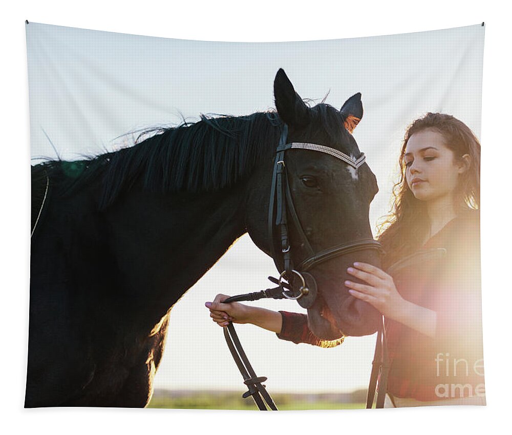 Woman Tapestry featuring the photograph Attractive young woman holding a dark horse on a harness. by Michal Bednarek