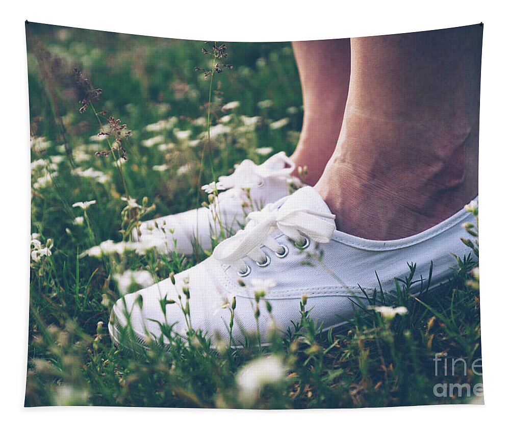Woman Tapestry featuring the photograph Woman in sneakers standing on meadow with flowers. by Michal Bednarek