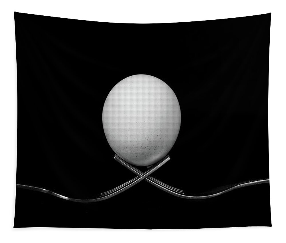 Egg Tapestry featuring the photograph White egg resting on two metal and shiny forks on a black backg by Michalakis Ppalis