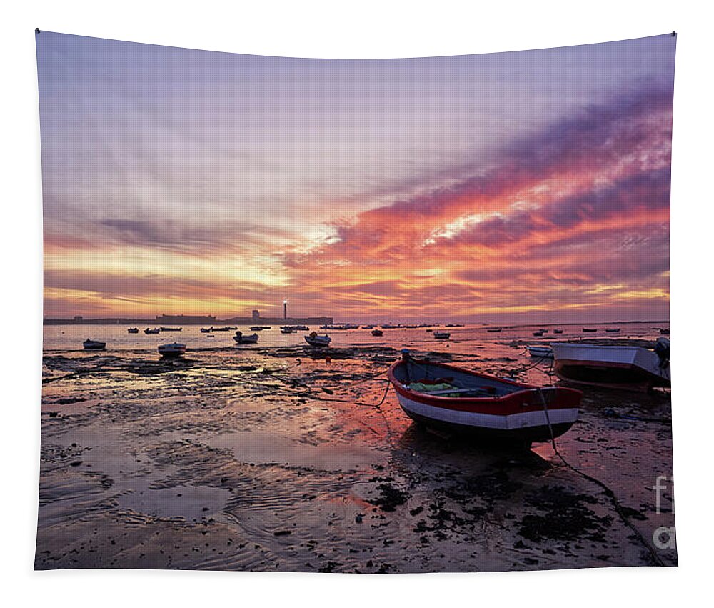 Shore Tapestry featuring the photograph Boats at La Caleta Beach at Dusk under a Fiery Sky Cadiz by Pablo Avanzini