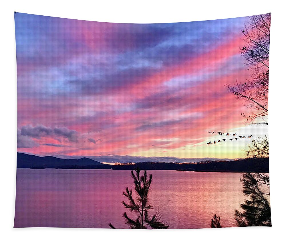 Canadian Geese Tapestry featuring the photograph Canadian Geese over Smith Mountain Lake at Sunset. by The James Roney Collection