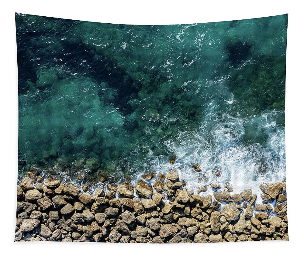 Seascape Tapestry featuring the photograph Aerial view from flying drone of crystal blue ocean water and sea wall. by Michalakis Ppalis
