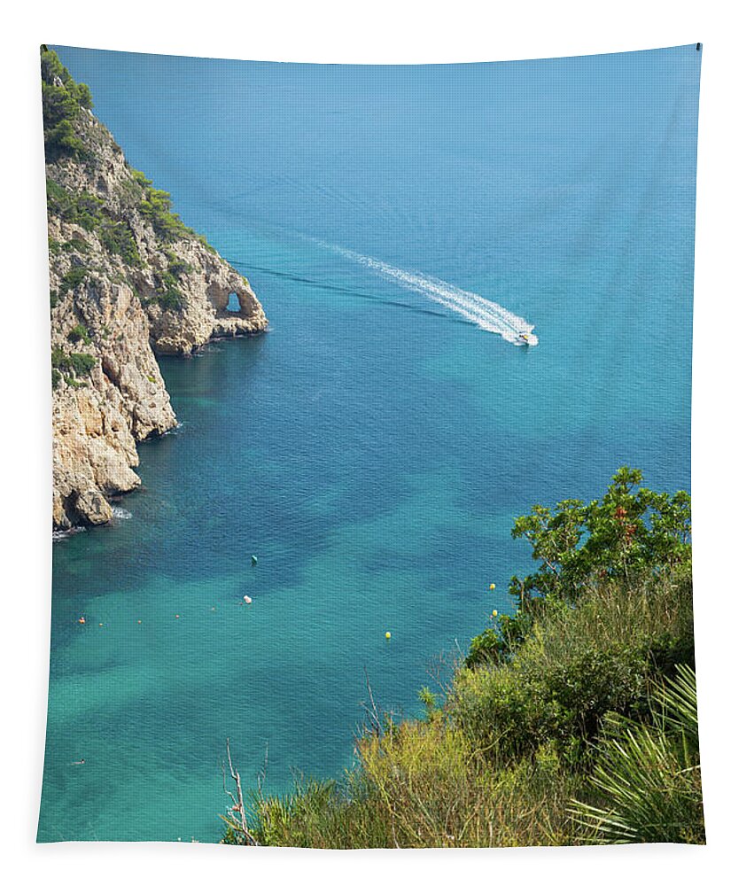 Mediterranean Sea Tapestry featuring the photograph Seawater and motor boat. Cala de la Granadella by Adriana Mueller