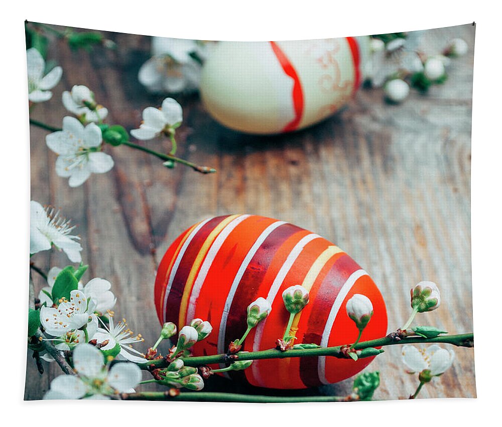 Easter Tapestry featuring the photograph Closeup of colorful painted easter eggs and cherry blossom branc by Jelena Jovanovic