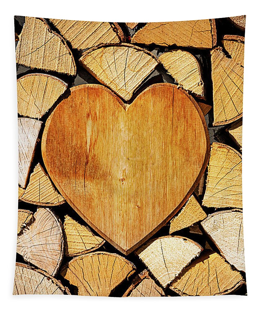 Pile Tapestry featuring the photograph Stack of firewood with a wooden heart by Bernhard Schaffer