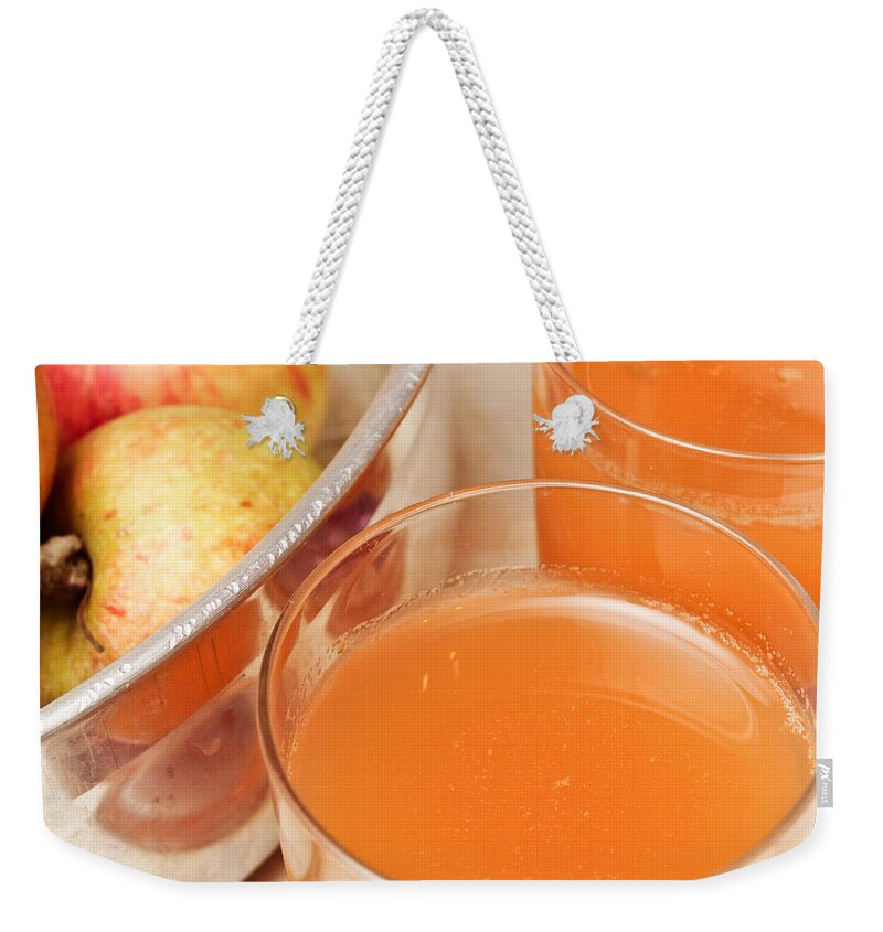 Apple Weekender Tote Bag featuring the photograph Apple juice #1 by Tom Gowanlock