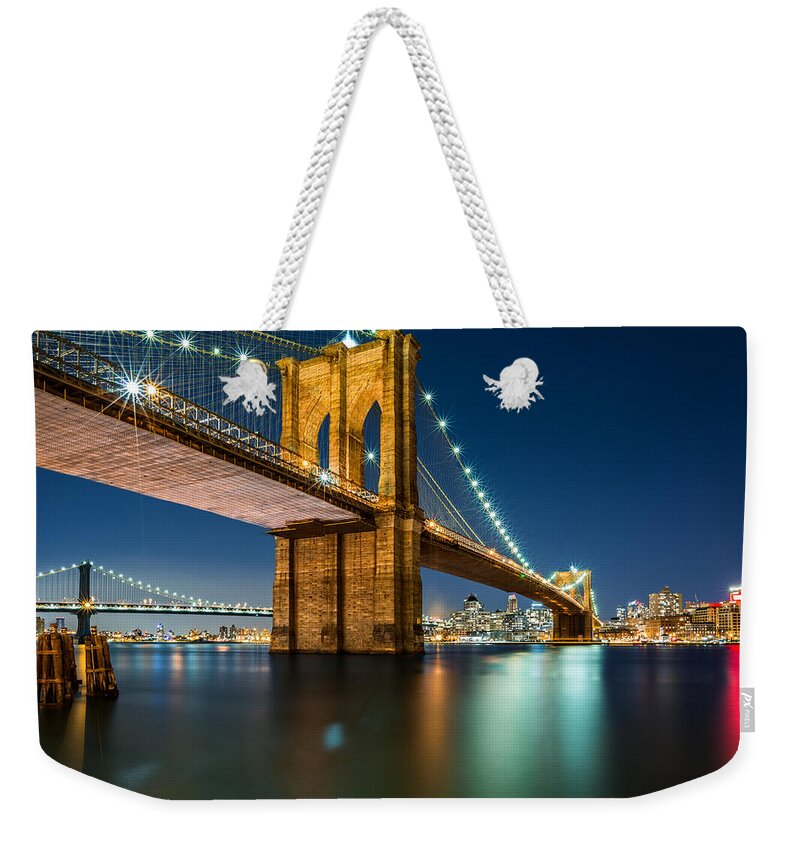 Architecture Weekender Tote Bag featuring the photograph Illuminated Brooklyn Bridge by night #1 by Mihai Andritoiu