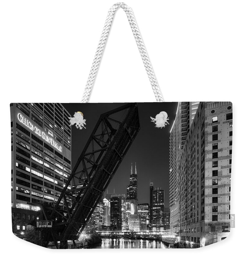 Architecture Weekender Tote Bag featuring the photograph Kinzie Street railroad bridge at night in Black and White #1 by Sebastian Musial