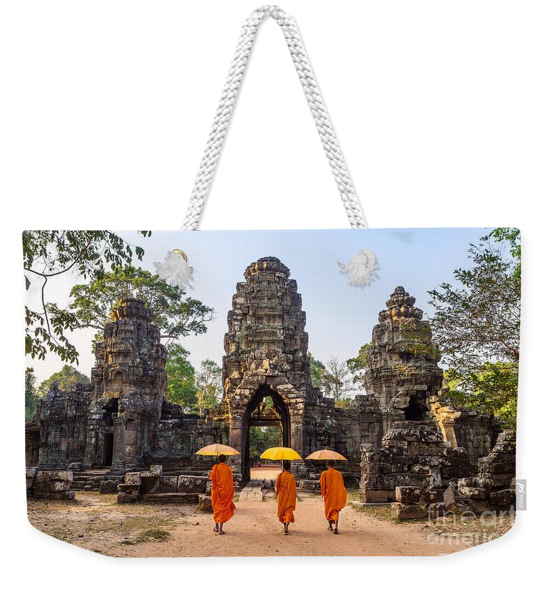 Angkor Weekender Tote Bag featuring the photograph Monks with umbrella walking into Angkor Wat temple - Cambodia #1 by Matteo Colombo
