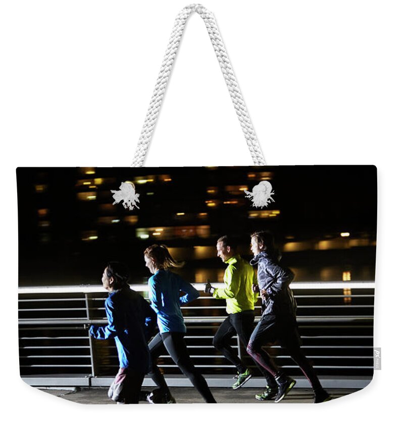 Young Men Weekender Tote Bag featuring the photograph Small Group Of Runners #1 by Henrik Sorensen