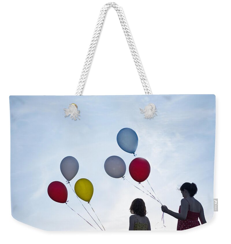 Girl Weekender Tote Bag featuring the photograph Two Girls With Balloons #1 by Lee Avison
