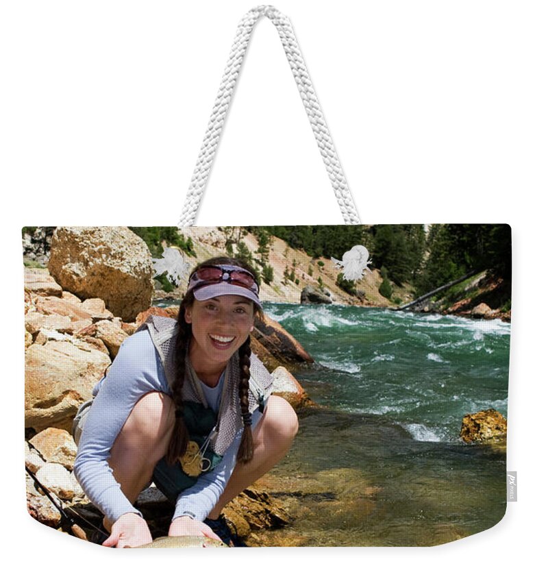Adventure Weekender Tote Bag featuring the photograph A Woman Smiles As She Catches by Scott Dickerson