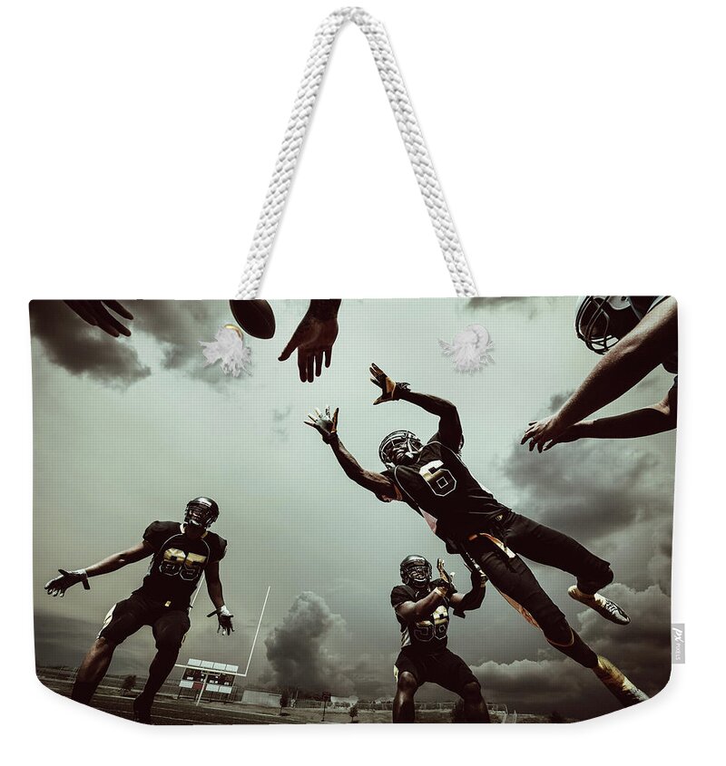 Sports Helmet Weekender Tote Bag featuring the photograph American Football Match by Ferrantraite