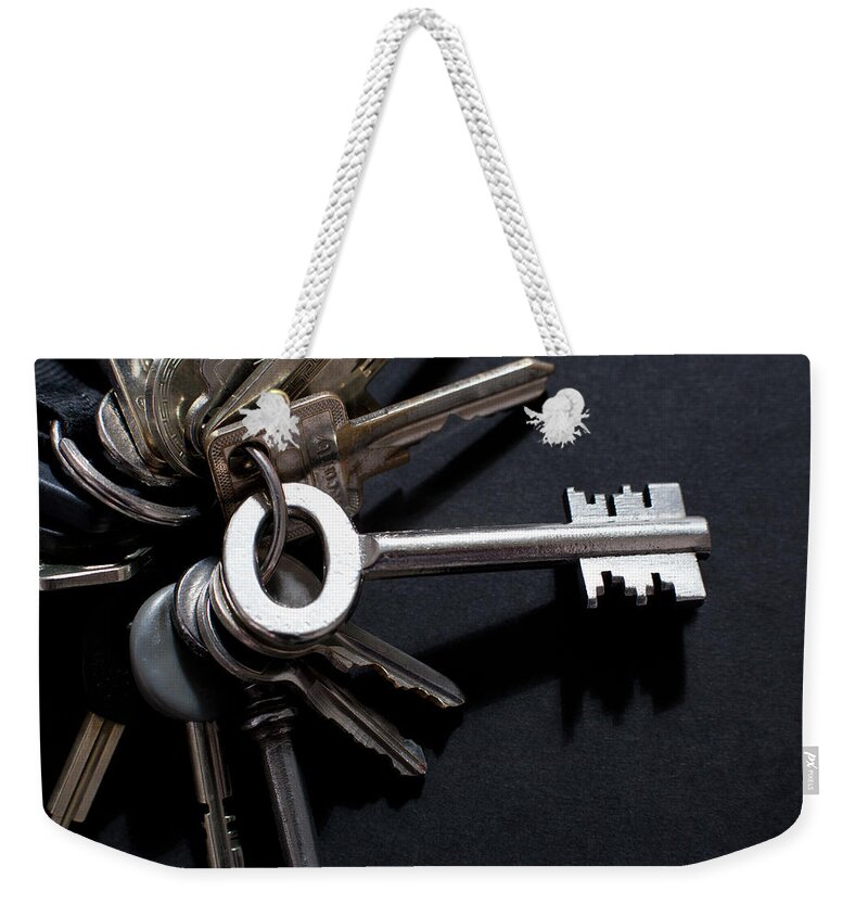 Security Weekender Tote Bag featuring the photograph An Odd Shaped Old-fashioned Key by Larry Washburn