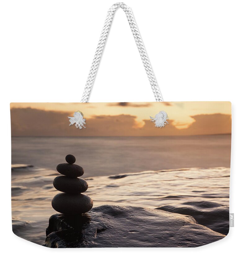 Dorset Weekender Tote Bag featuring the photograph Balancing Pebbles At Sunset by Travelpix Ltd