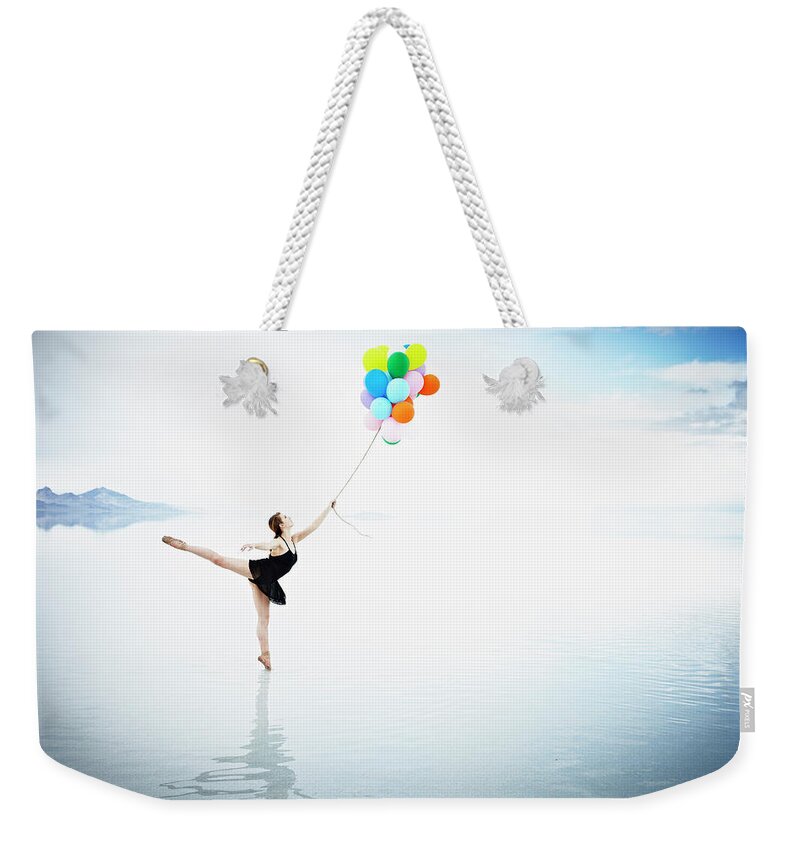 Tranquility Weekender Tote Bag featuring the photograph Ballerina On Tip Toe In Water Holding by Thomas Barwick