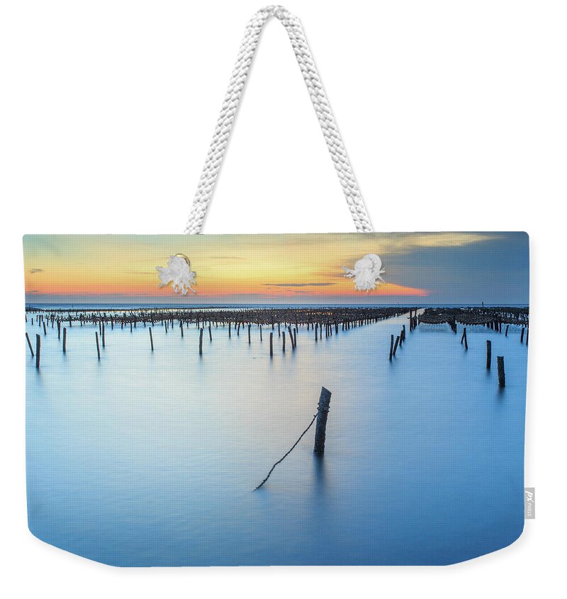 Tranquility Weekender Tote Bag featuring the photograph Bamboo Poles And Rope In Oyster Farm by Samyaoo