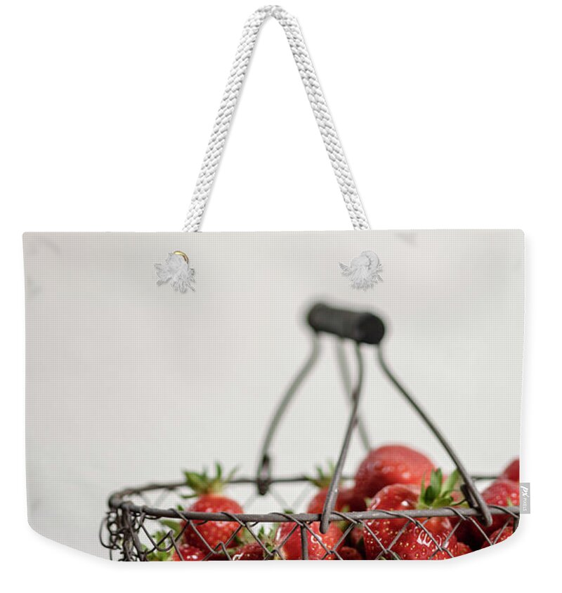 Handle Weekender Tote Bag featuring the photograph Basket Of Strawberries On Wooden Table by Westend61