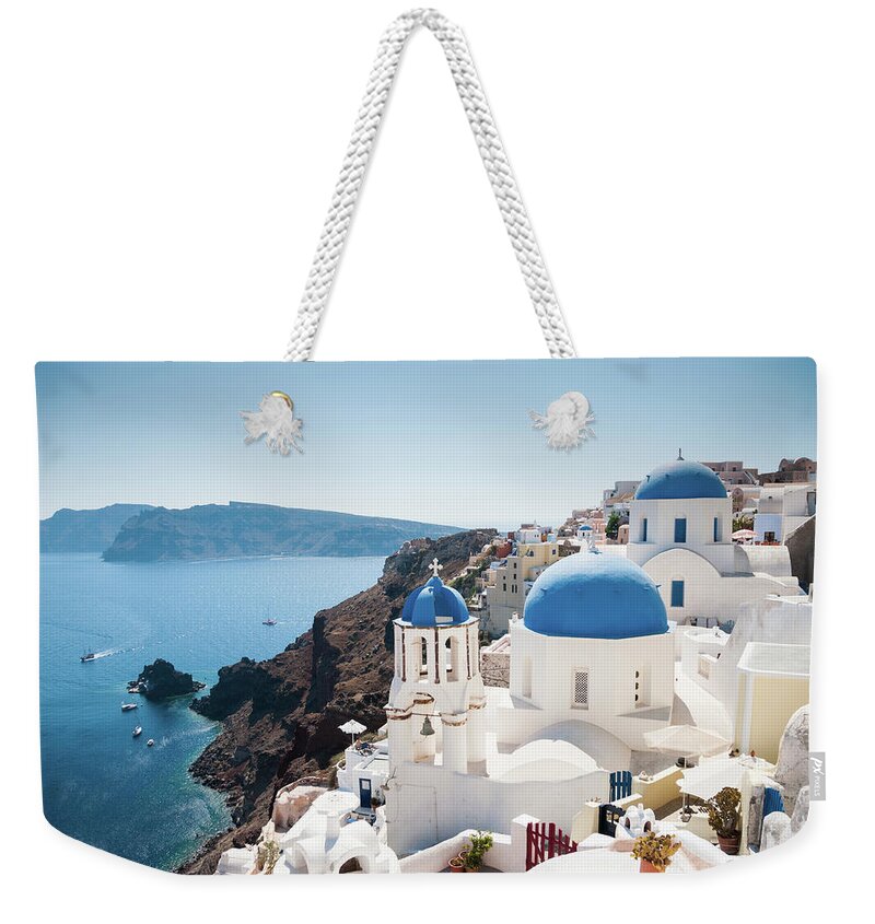 Greek Culture Weekender Tote Bag featuring the photograph Blue Domed Church Along Caldera Edge In by Gollykim