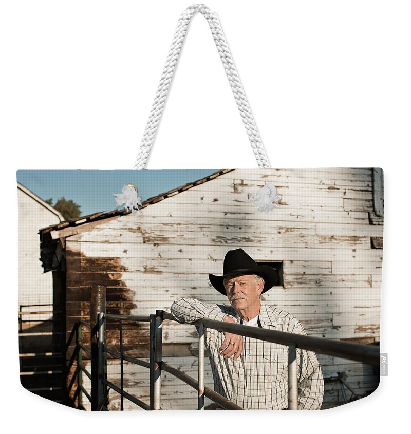 People Weekender Tote Bag featuring the photograph Caucasian Rancher Standing At Gate by Hill Street Studios