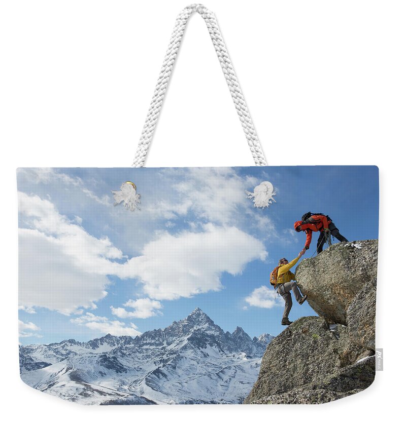 Young Men Weekender Tote Bag featuring the photograph Climber Extends Helping Hand To Teammate by Ascent Xmedia