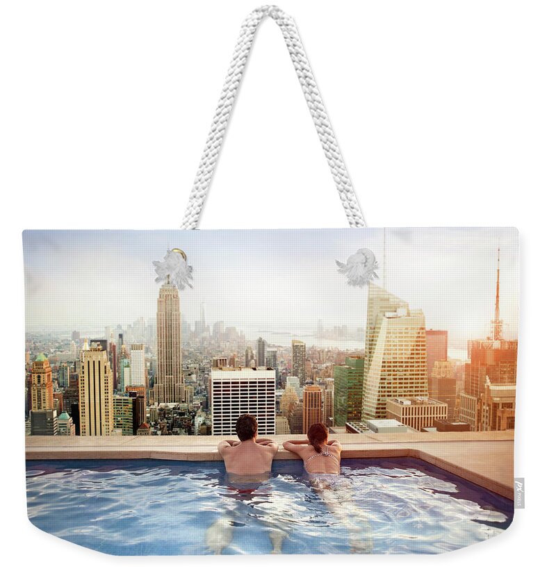 Recreational Pursuit Weekender Tote Bag featuring the photograph Couple Relaxing On Hotel Rooftop by Orbon Alija