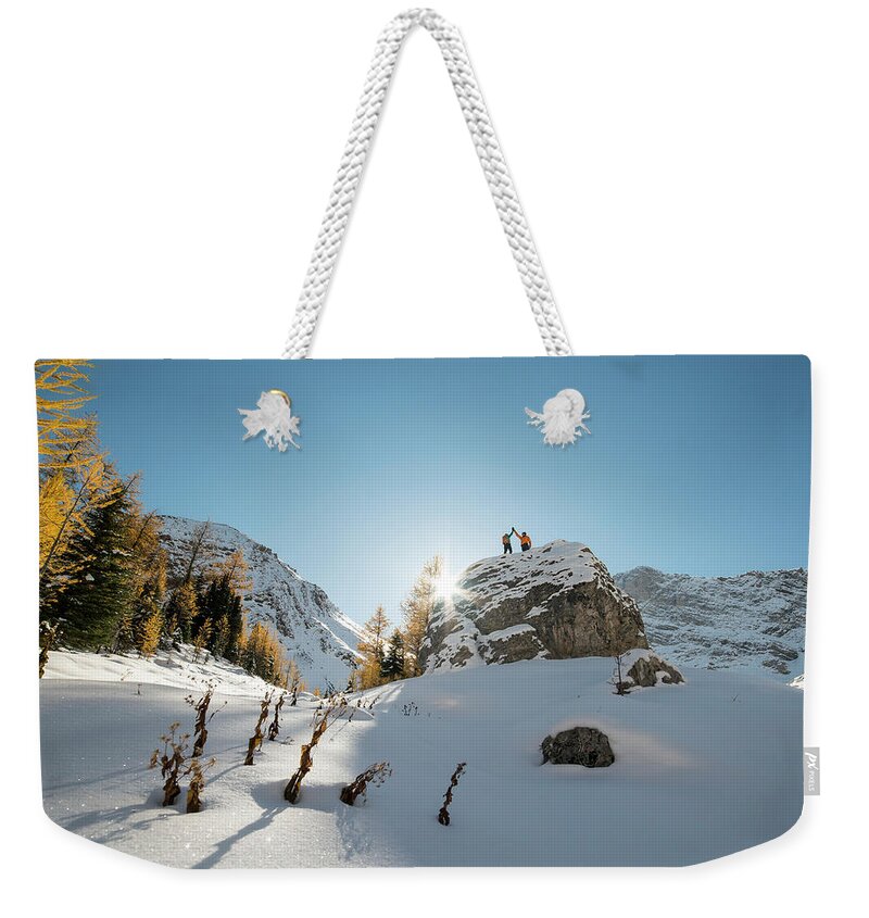 Scenics Weekender Tote Bag featuring the photograph Distant Hikers High-five On Snowy Summit by Ascent Xmedia