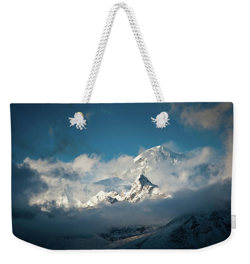 Himalayas Weekender Tote Bag featuring the photograph Dramatic Clouds Swirling Around Snowy by Fotovoyager