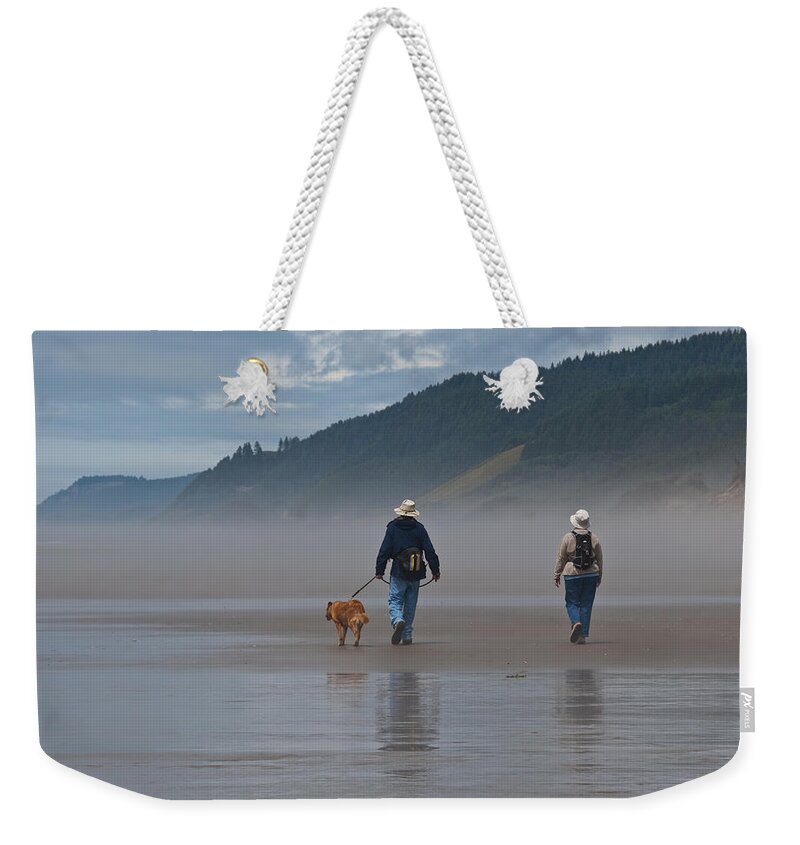 Active Seniors Weekender Tote Bag featuring the photograph Elderly Couple Walking a Dog by Jeff Goulden