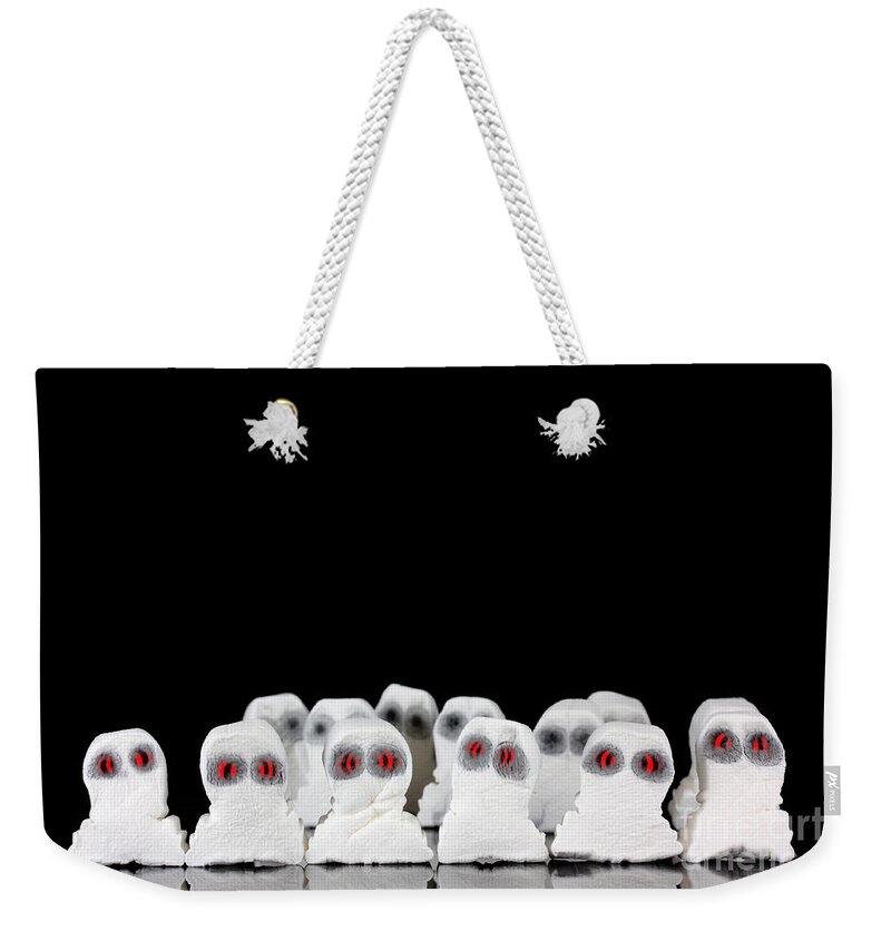 Black Weekender Tote Bag featuring the photograph Evil white ghosts in a crowd with black space by Simon Bratt