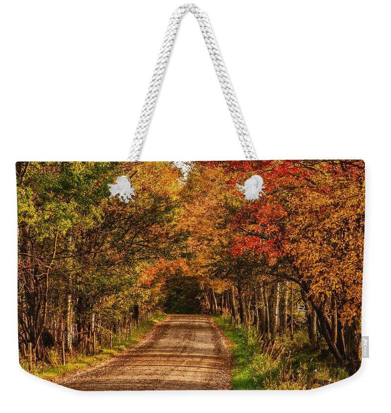 Peacham Vermont Weekender Tote Bag featuring the photograph Fall color along a dirt backroad by Jeff Folger