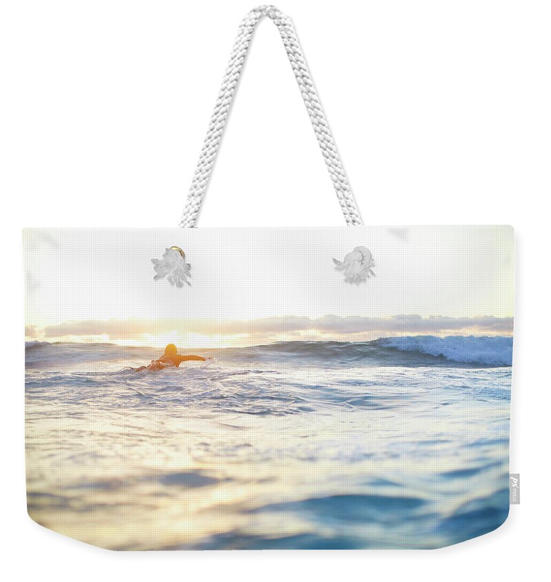 People Weekender Tote Bag featuring the photograph Female Surfer Swimming Out To Waves On by Moof