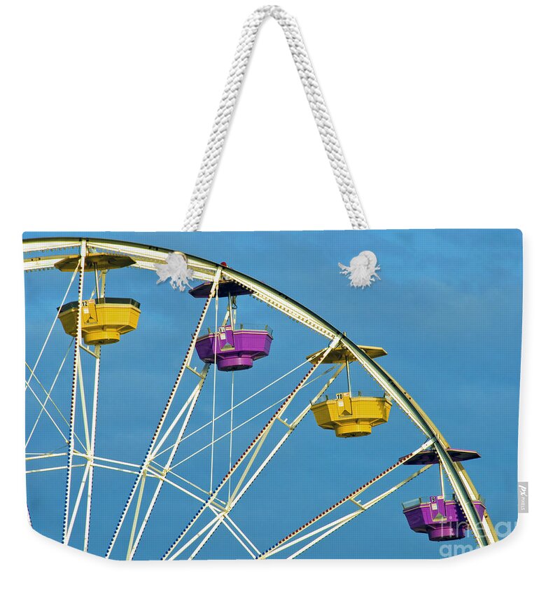 Ferris Wheel Weekender Tote Bag featuring the photograph Ferris Wheel rotating upright wheel with passenger cars by David Zanzinger
