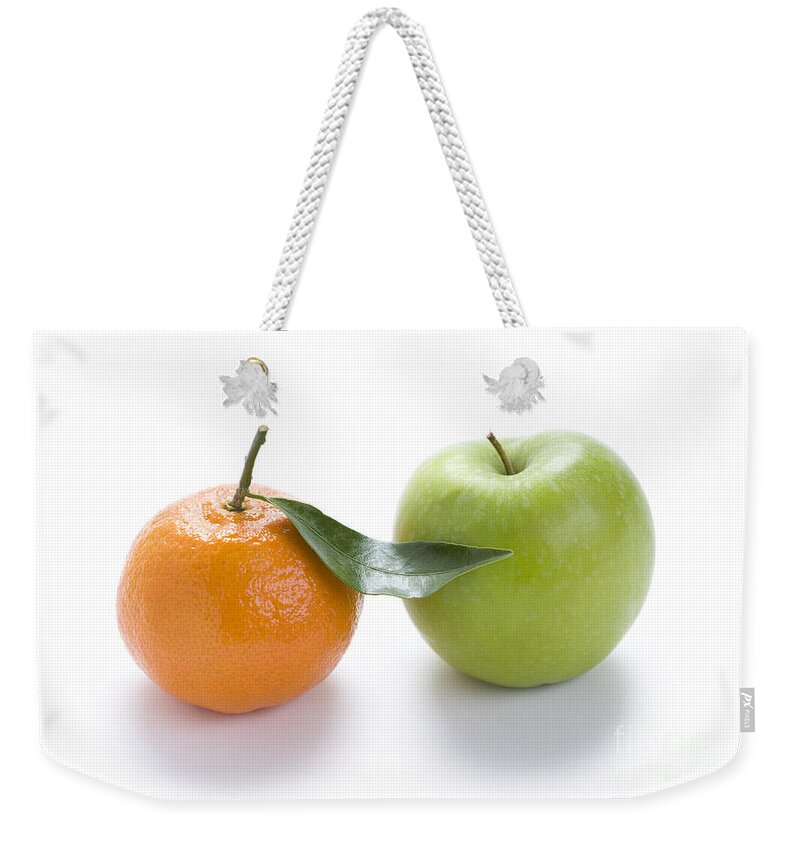 Oranges And Apples Weekender Tote Bag featuring the photograph Fresh Apple And Orange On White by Lee Avison