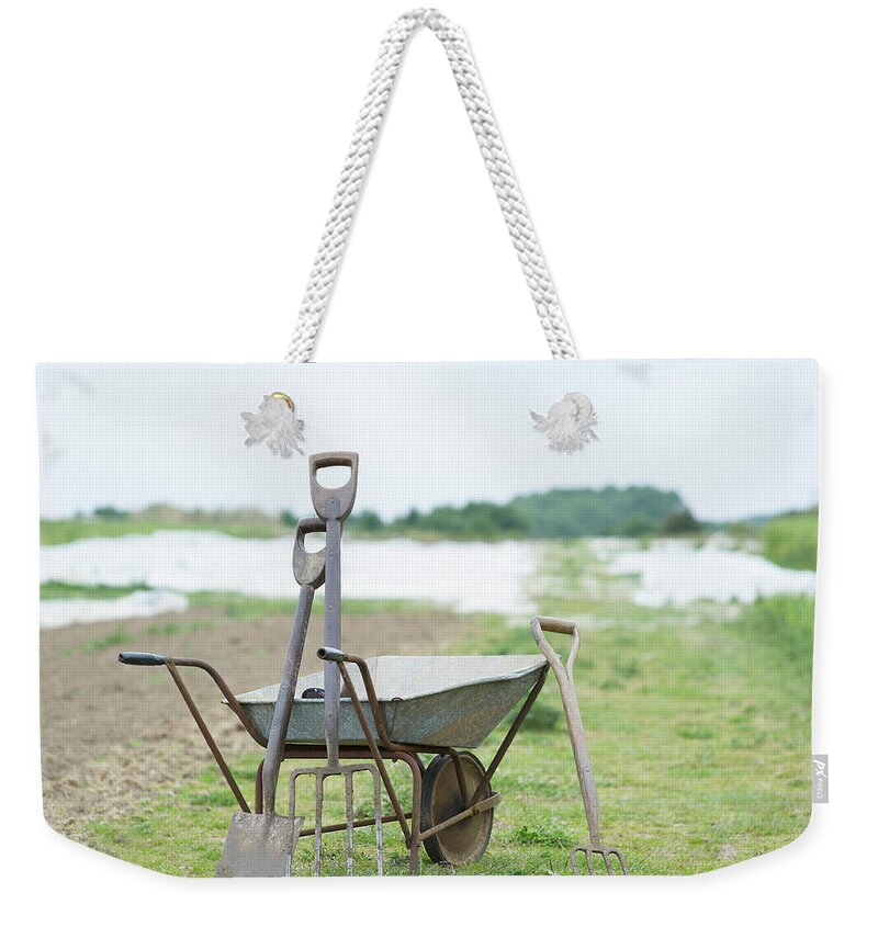 Grass Weekender Tote Bag featuring the photograph Gardening Tools And Wheel Barrow On by Dougal Waters