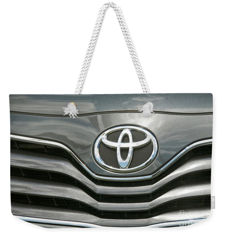 Grey Toyota Grill Headlight Cars Weekender Tote Bag featuring the photograph Grey Toyota Grill and Emblem Smile by David Zanzinger
