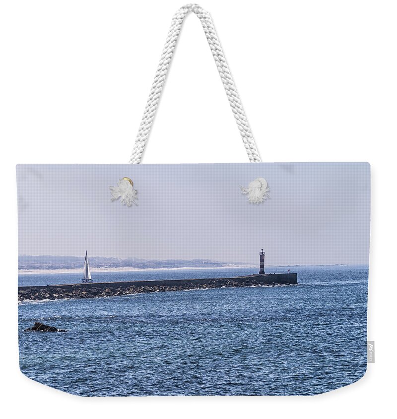 Lighthouse Weekender Tote Bag featuring the photograph Lighthouse and a sailing boat by Paulo Goncalves