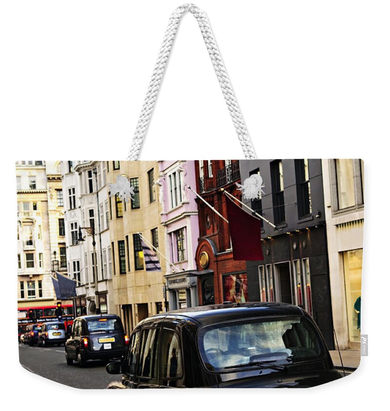 London Weekender Tote Bag featuring the photograph London taxi on shopping street by Elena Elisseeva