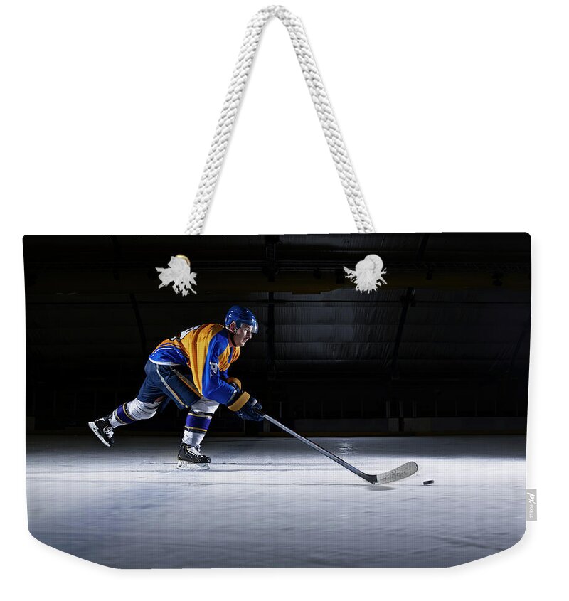 Focus Weekender Tote Bag featuring the photograph Male Ice Hockey Player Skating With by Mike Harrington