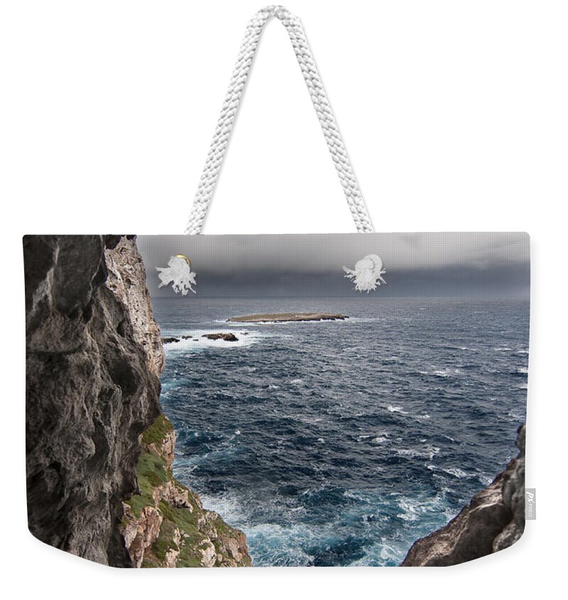 Background Weekender Tote Bag featuring the photograph A natural window in Minorca north coast discover us an impressive view of sea and sky - Open window by Pedro Cardona Llambias