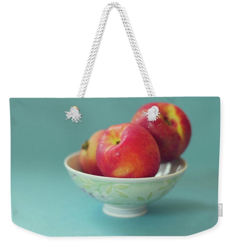 Close-up Weekender Tote Bag featuring the photograph Peaches In Bowl On Blue Background by Copyright Anna Nemoy(xaomena)
