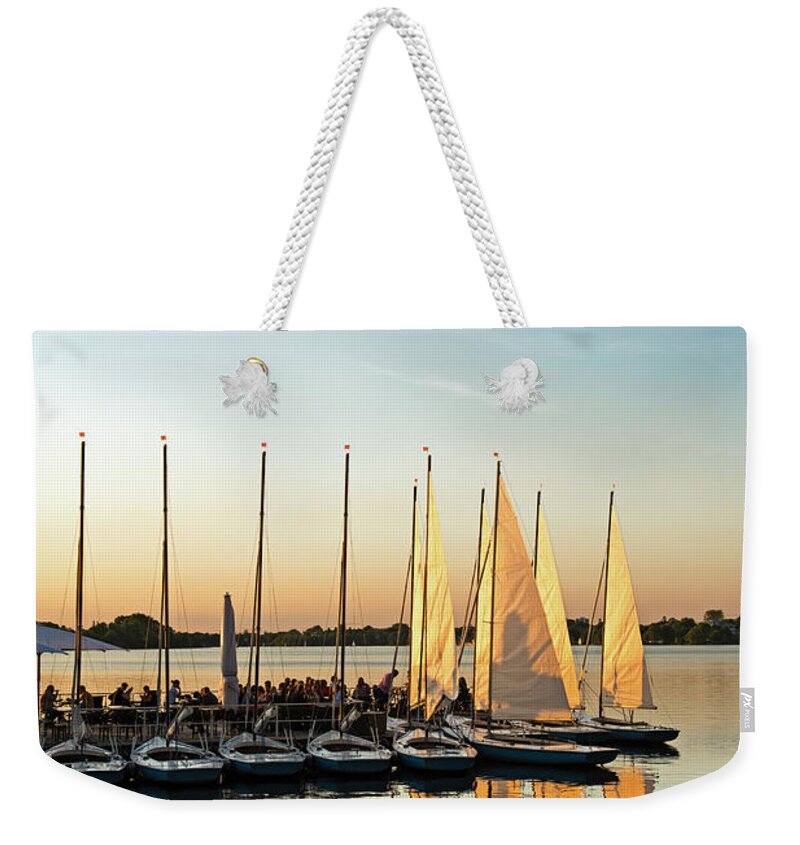 Pole Weekender Tote Bag featuring the photograph People Relaxing At Yacht Harbor At by Thomas Winz